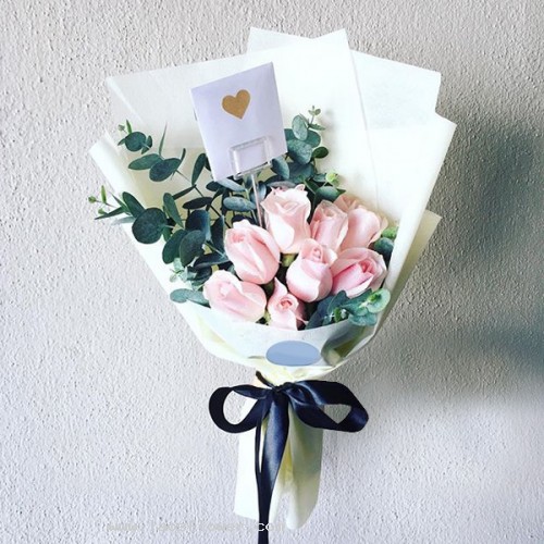 10 pink roses bouquet arranged to show one-sided accent with eucalyptus.